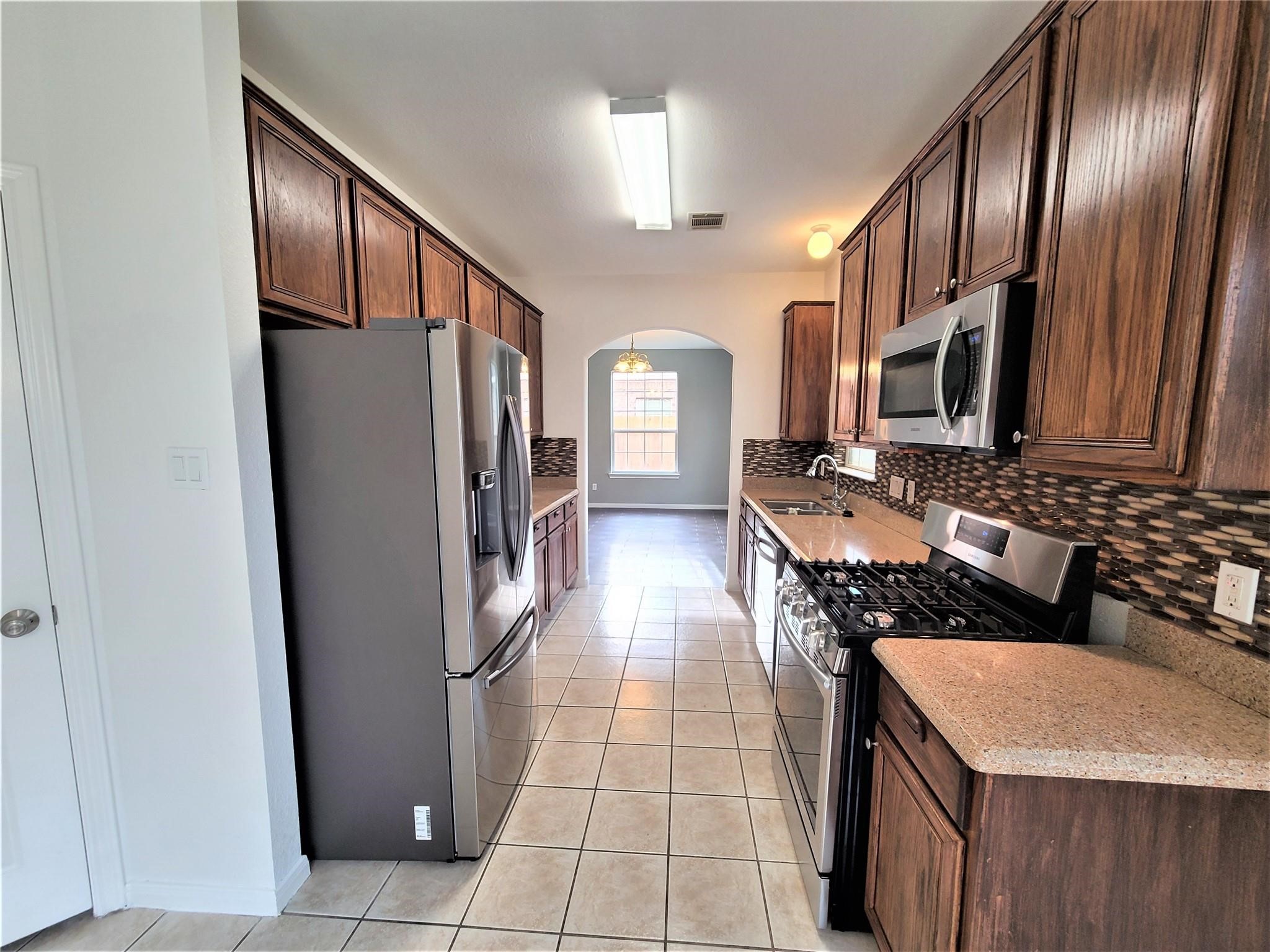 10026 Gil Jr Lane Houston, TX 77075 - Photo 5 of 14 a kitchen with stainless steel appliances granite countertop a refrigerator a stove and a sink
