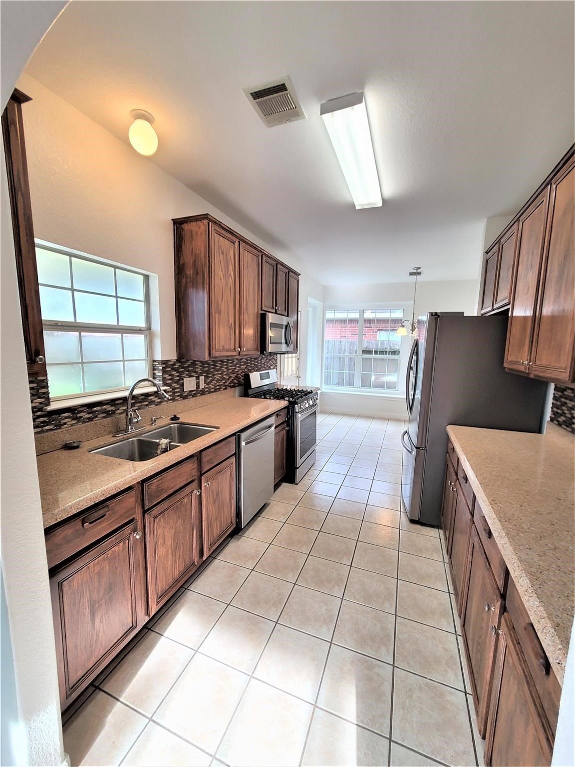 10026 Gil Jr Lane Houston, TX 77075 - Photo 6 of 14 a large kitchen with stainless steel appliances granite countertop a stove sink and cabinets