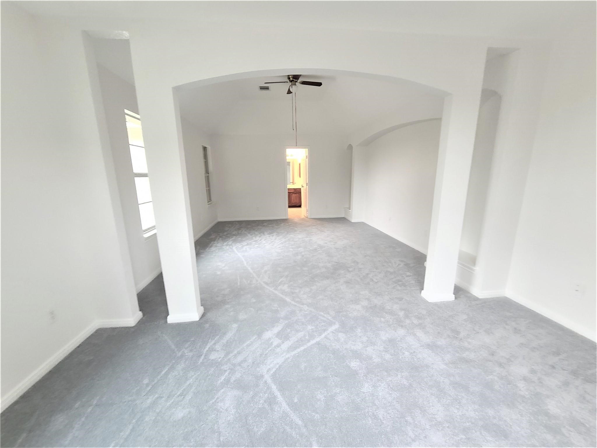 10026 Gil Jr Lane Houston, TX 77075 - Photo 7 of 14 an empty room with a fireplace and windows