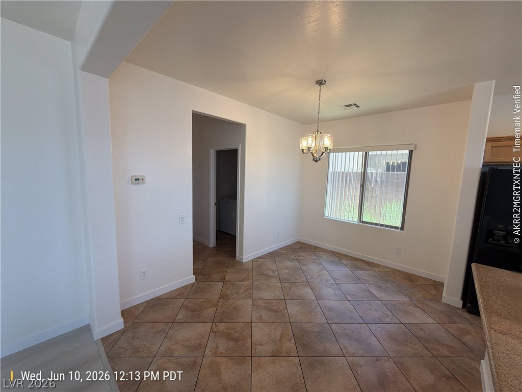 2388 Rue Bienville Way Henderson, NV 89044 - Photo 5 of 16 A well-lit dining area featuring elegant tile flooring and a modern chandelier, perfect for intimate gatherings.