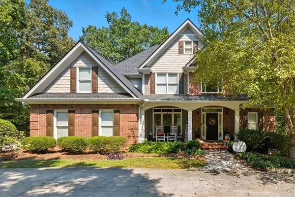 a front view of a house with yard and green space
