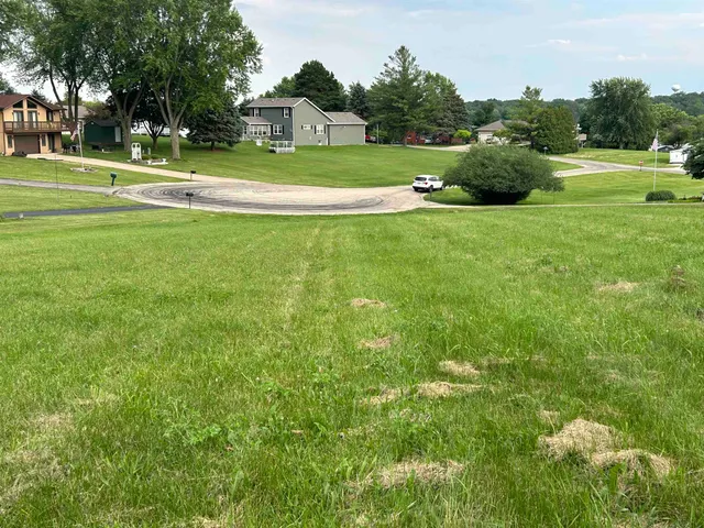 a view of a house with a big yard and large trees