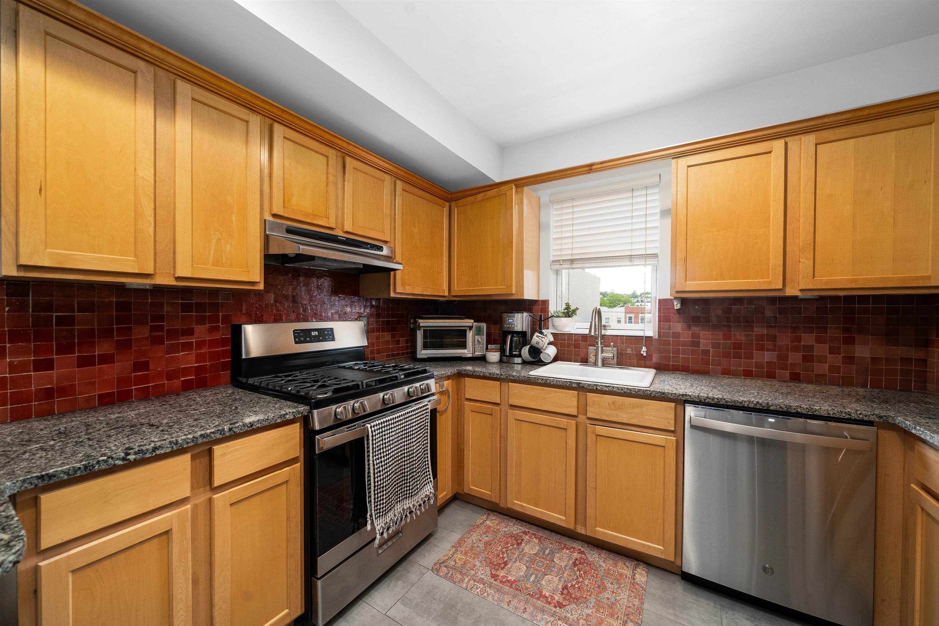 536 Grand Street, Unit 403 Hoboken, NJ 07030 - Photo 5 of 15 a kitchen with stainless steel appliances granite countertop stove top oven a sink and dishwasher