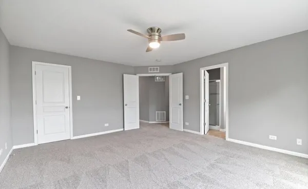 a view of an empty room with a ceiling fan