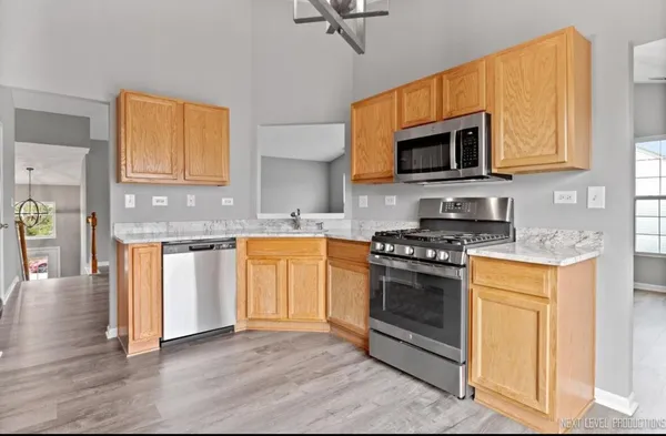 a kitchen with stainless steel appliances granite countertop a stove a sink and a microwave