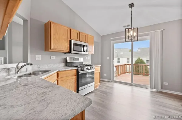 a kitchen with stainless steel appliances granite countertop a stove top oven a sink a oven with a dining table and chairs