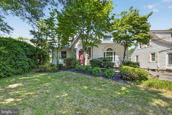 a front view of a house with a yard and potted plants