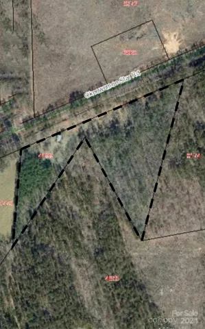 a view of a dry yard with wooden fence