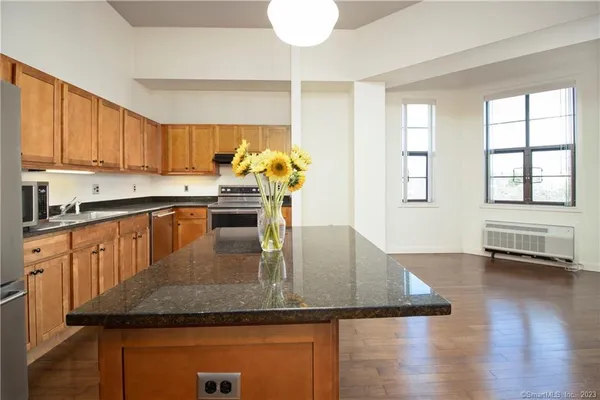 a kitchen with stainless steel appliances granite countertop a sink window and cabinets