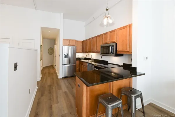 a kitchen with stainless steel appliances granite countertop a stove a sink and a refrigerator