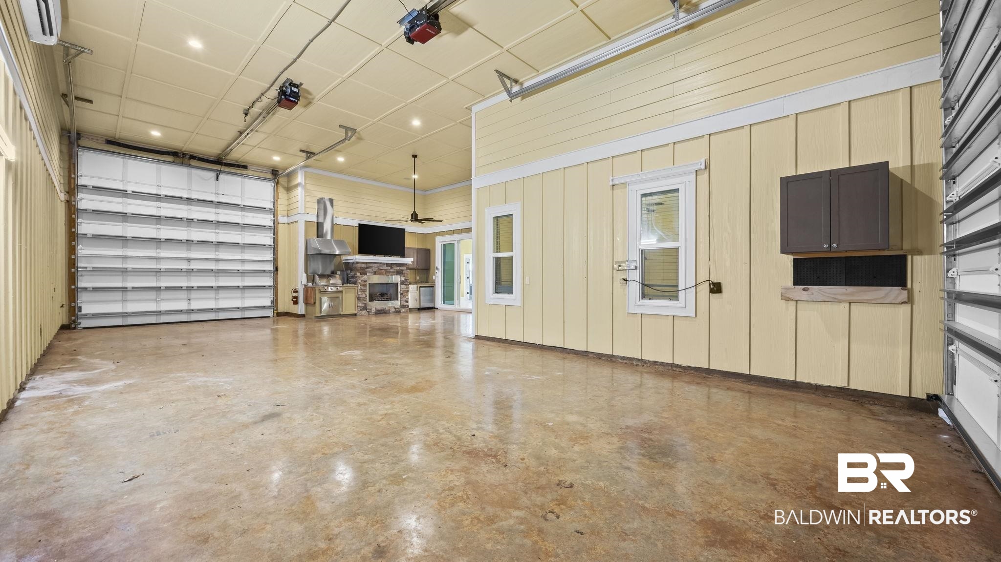 12361 Reunion Place Foley, AL 36535 - Photo 17 of 43 Garage featuring wood walls, a wall unit AC, recessed lighting, and a garage door opener