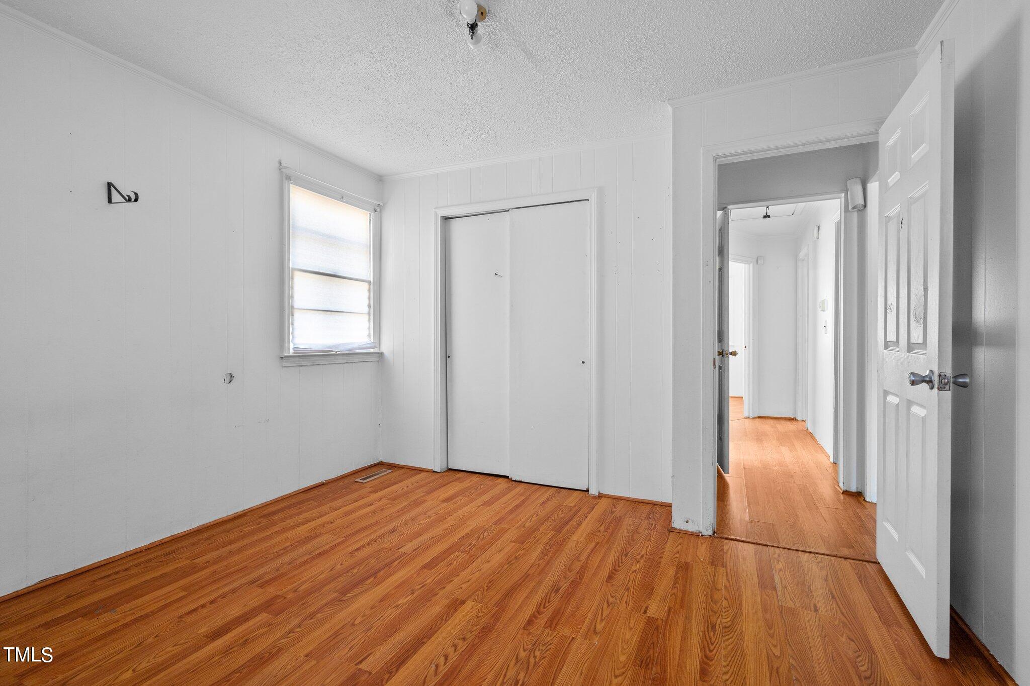 223 Gentry Street Roxboro, NC 27573 - Photo 14 of 36 a view of an empty room with wooden floor and a window