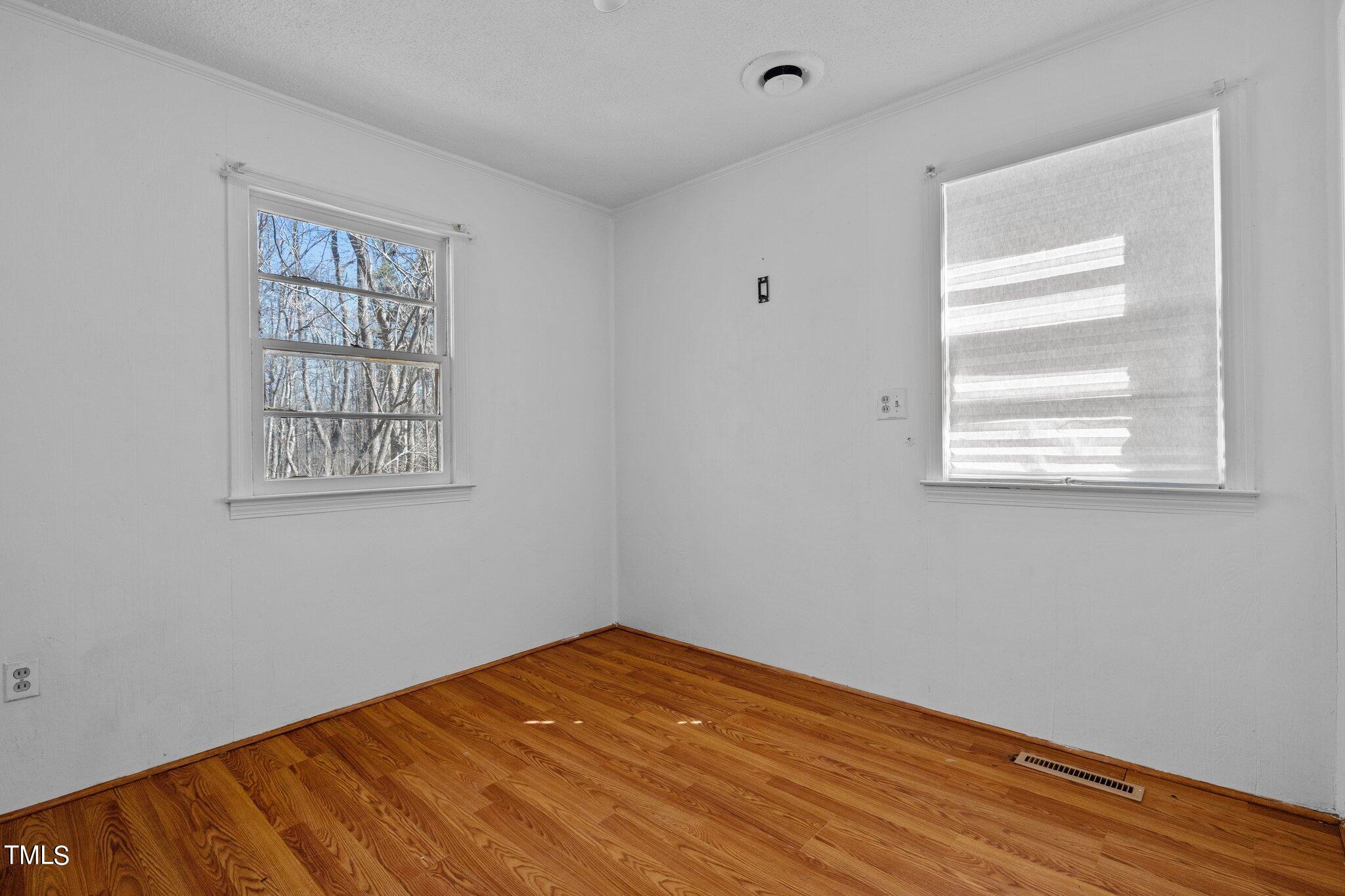 223 Gentry Street Roxboro, NC 27573 - Photo 17 of 36 a view of an empty room with wooden floor and a window