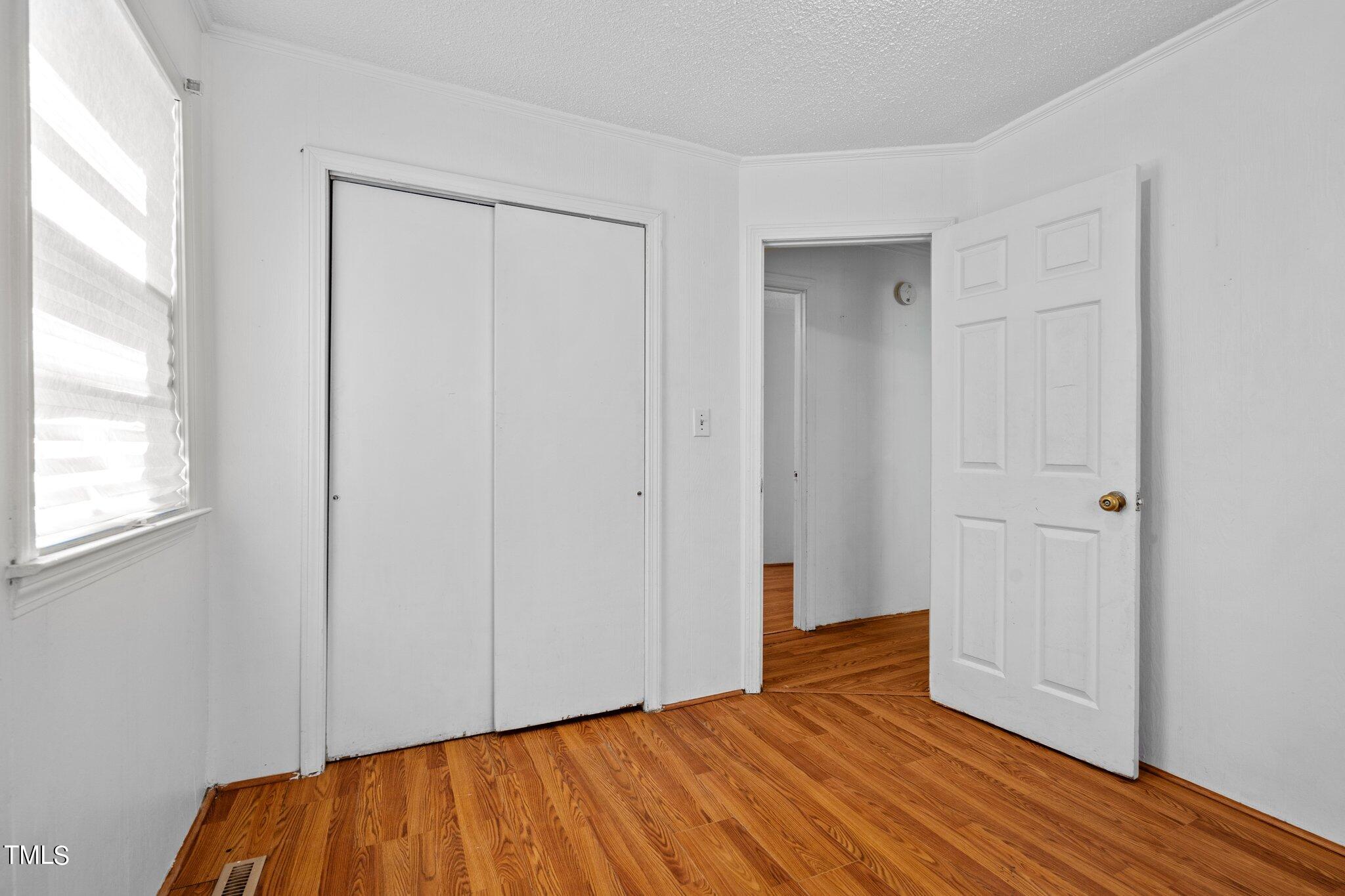 223 Gentry Street Roxboro, NC 27573 - Photo 19 of 36 a view of an empty room with wooden floor