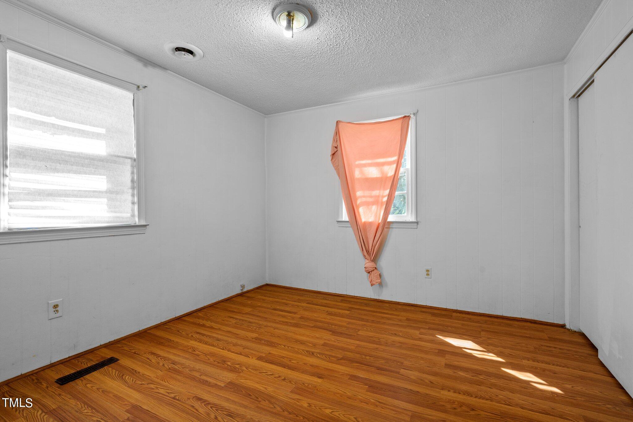 223 Gentry Street Roxboro, NC 27573 - Photo 20 of 36 a view of empty room with wooden floor and fan