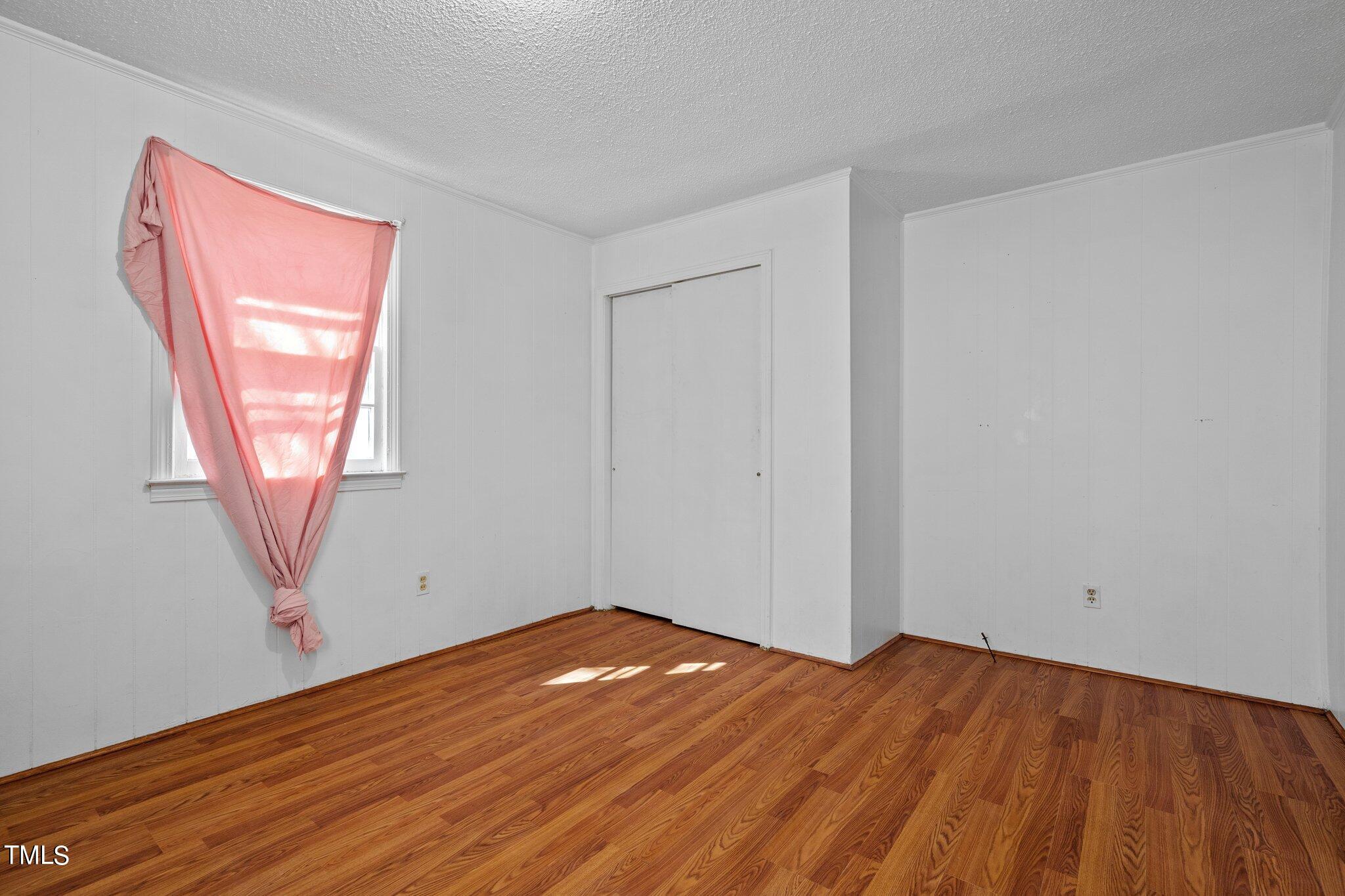 223 Gentry Street Roxboro, NC 27573 - Photo 22 of 36 an empty room with wooden floor and windows