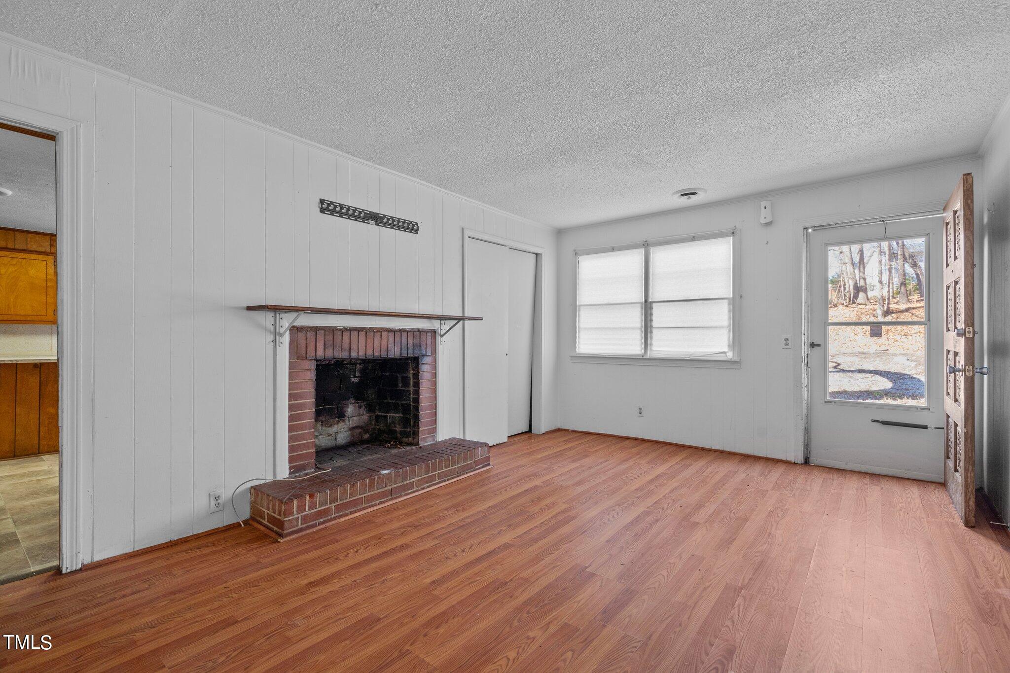 223 Gentry Street Roxboro, NC 27573 - Photo 5 of 36 wooden floor fireplace and windows in an empty room