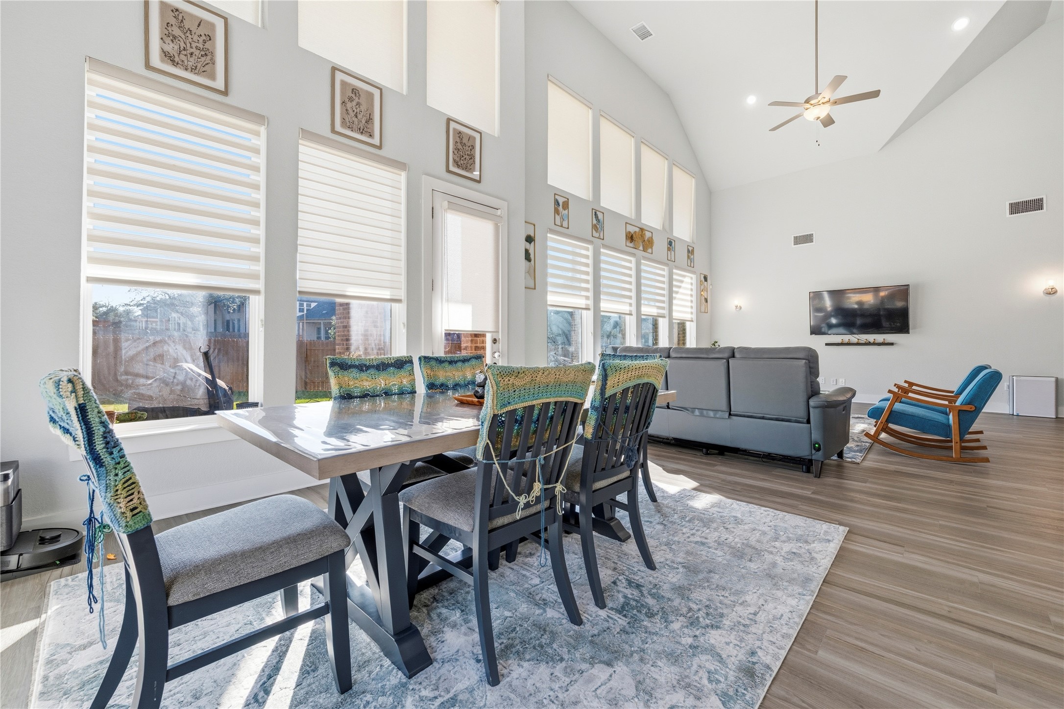 105 Autumn Oak Way Georgetown, TX 78628 - Photo 10 of 40 Open-concept living space featuring vaulted ceilings, wood-finish flooring, and ample natural light through tall windows