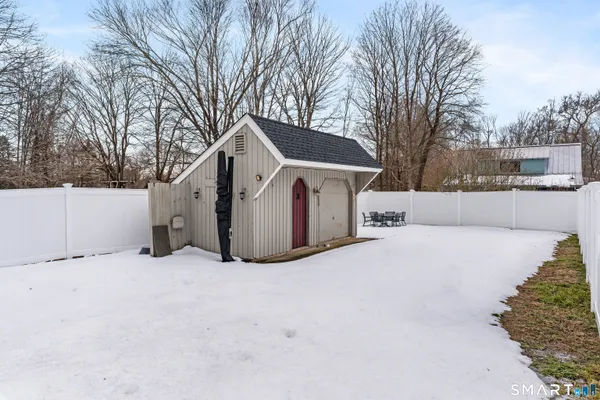 a front view of a house with a yard covered with snow