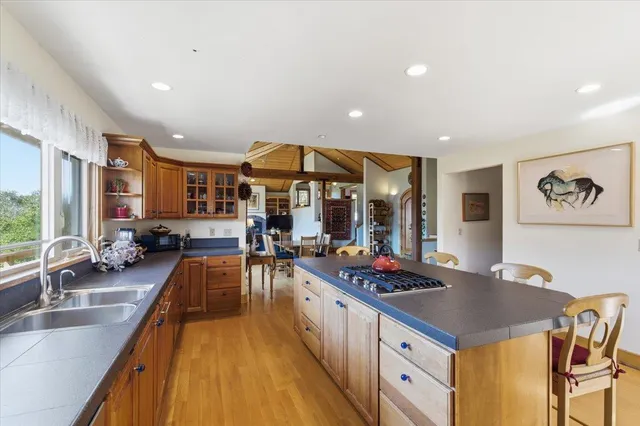 a kitchen with stainless steel appliances granite countertop dining table chairs and white cabinets