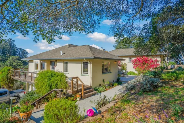 a front view of house with yard and trees in the background