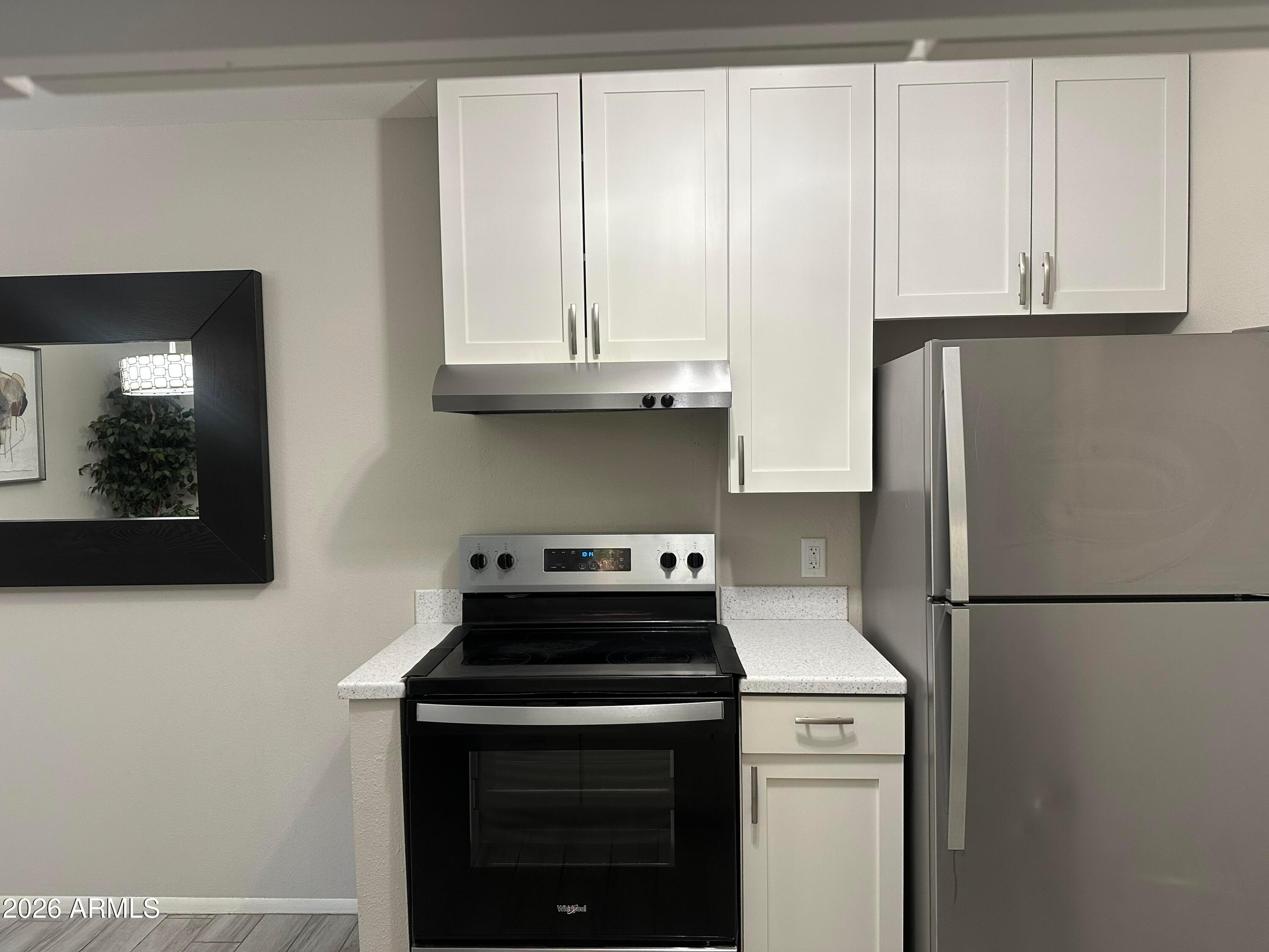 5525 East Thomas Road, Unit R8 Phoenix, AZ 85018 - Photo 7 of 21 a kitchen with stainless steel appliances granite countertop white refrigerator stove and white cabinets