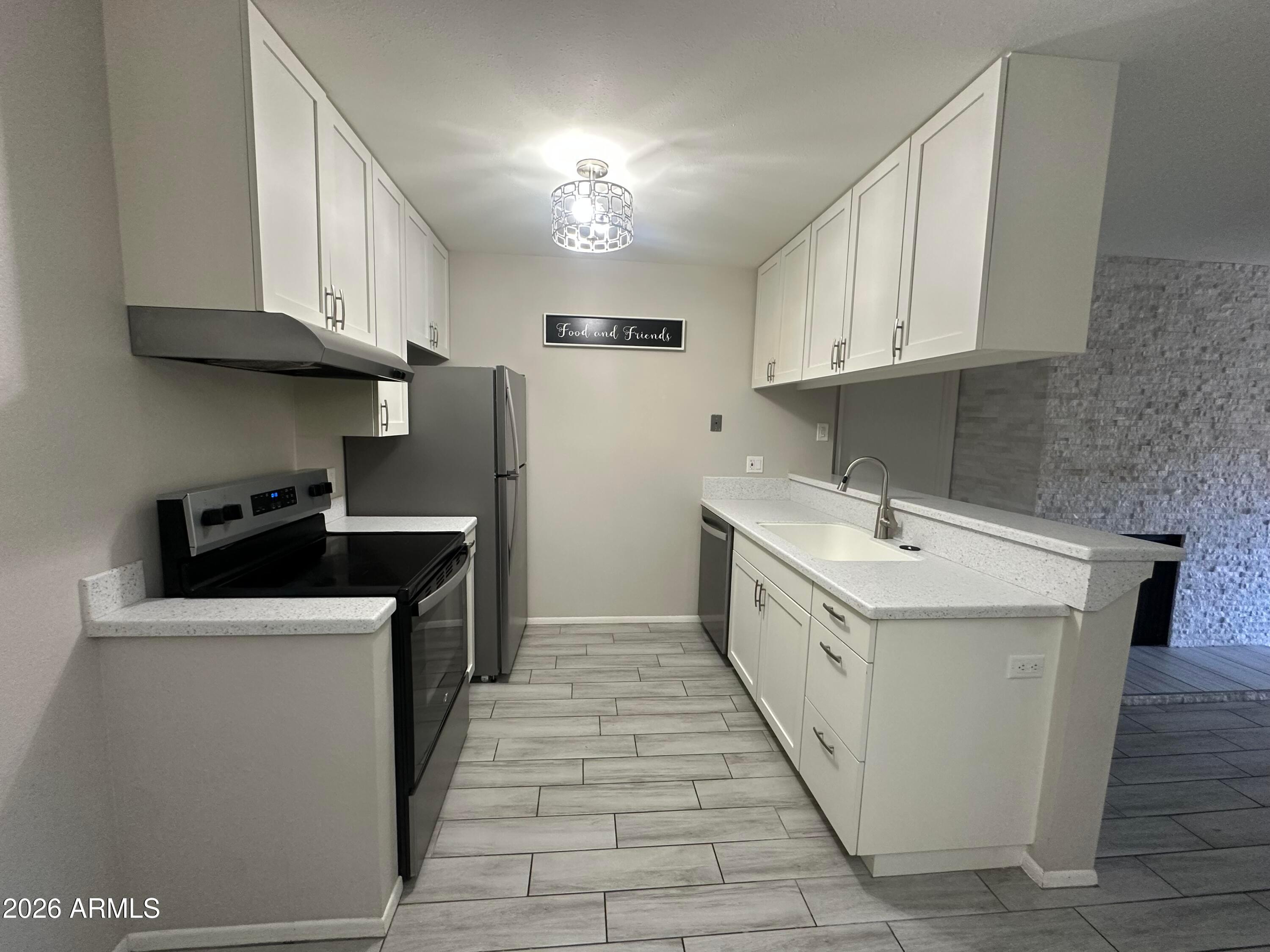 5525 East Thomas Road, Unit R8 Phoenix, AZ 85018 - Photo 8 of 21 a kitchen with a sink stove top oven and cabinets