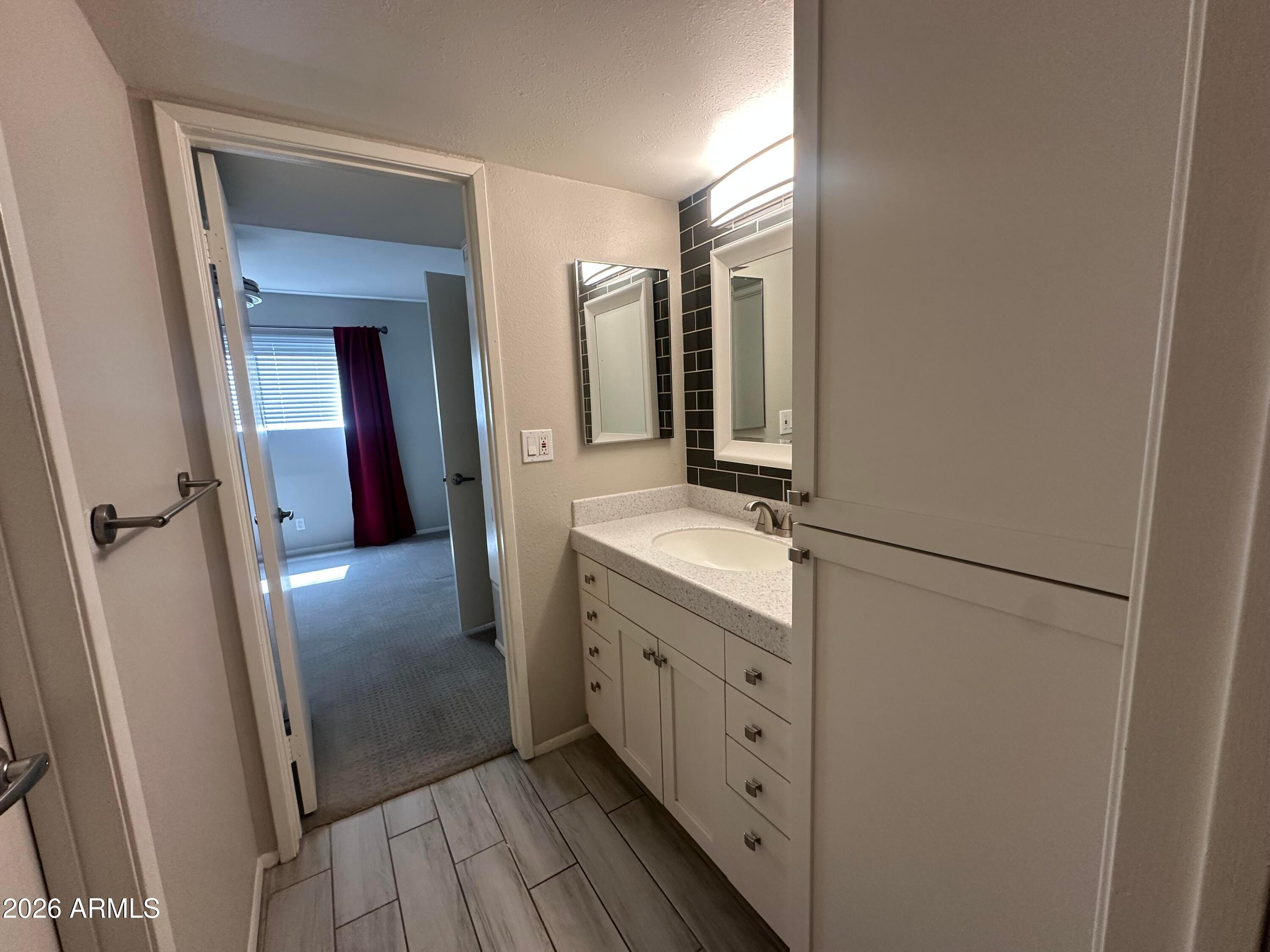 5525 East Thomas Road, Unit R8 Phoenix, AZ 85018 - Photo 10 of 21 a bathroom with a double vanity sink and mirror