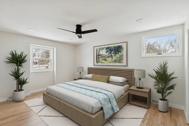 a bedroom with a large bed and a potted plant