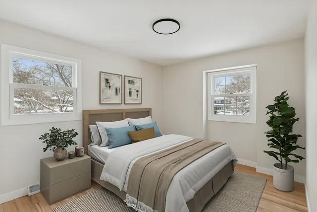 a bedroom with a large bed and a potted plant