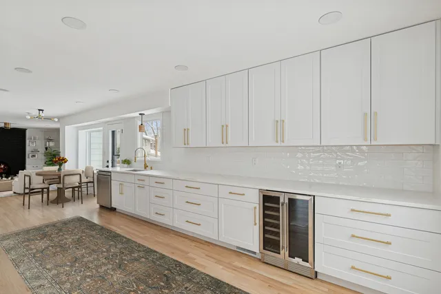 a kitchen with white cabinets and sink