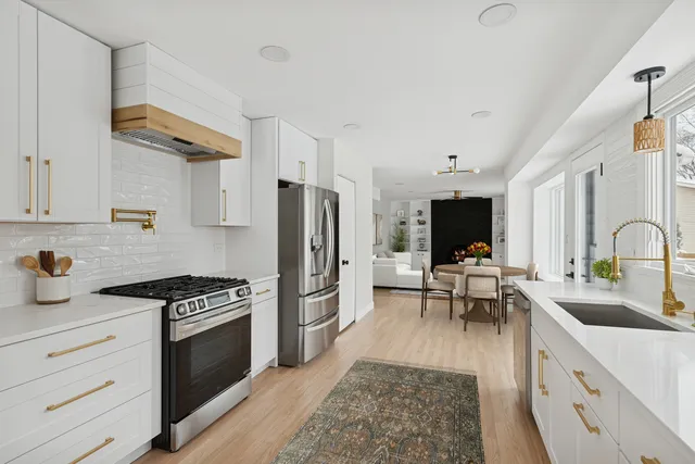 a kitchen with stainless steel appliances a stove a sink a refrigerator and cabinets