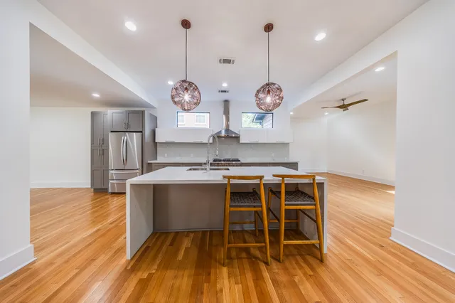 a large kitchen with stainless steel appliances a large counter top a stove and a sink