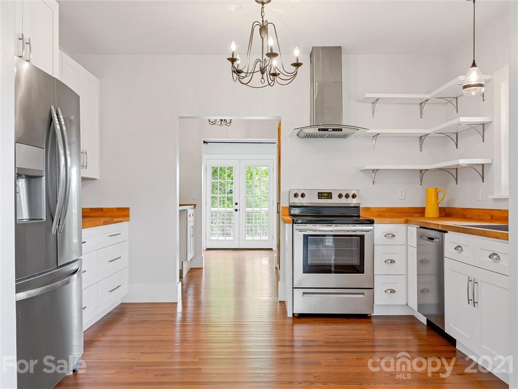714 Queentown Road Canton, NC 28716 - Photo 5 of 21 a kitchen with stainless steel appliances a stove a microwave and a hard wood floor