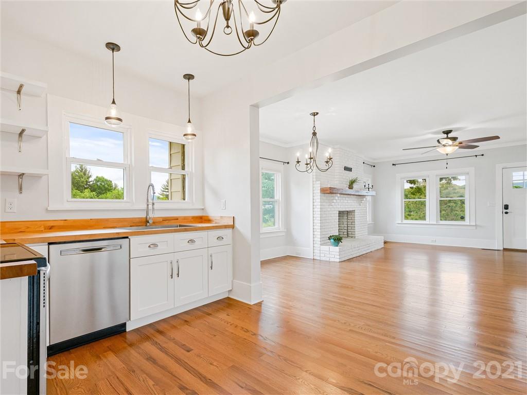 714 Queentown Road Canton, NC 28716 - Photo 6 of 21 a large kitchen with a sink dishwasher a fireplace with wooden floor