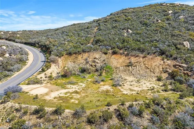 a view of a dry yard with wooden fence
