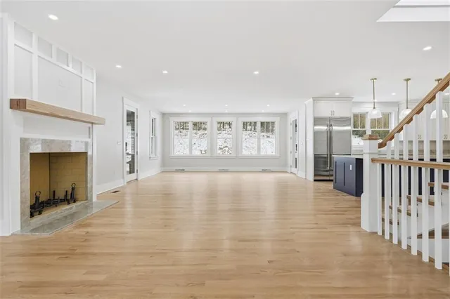 a view of empty room with wooden floor and fireplace