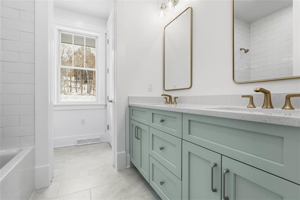 1502 Powers Run Road Pittsburgh, PA 15238 - Photo 23 of 33 a bathroom with a double vanity sink a mirror and a bathtub