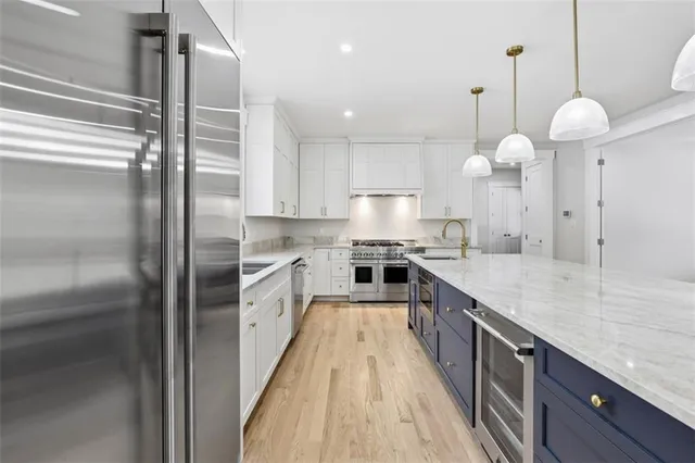 a large kitchen with granite countertop a large counter top space a sink stainless steel appliances and cabinets