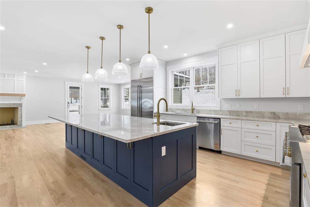 1502 Powers Run Road Pittsburgh, PA 15238 - Photo 7 of 33 a kitchen with stainless steel appliances granite countertop a sink a center island a stove and a wooden floor