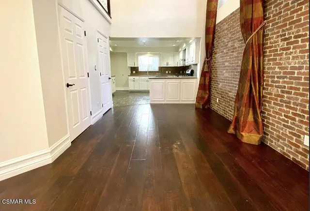 a view of a kitchen with wooden floor and electronic appliances