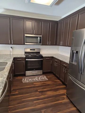 a kitchen with wooden cabinets and stainless steel appliances