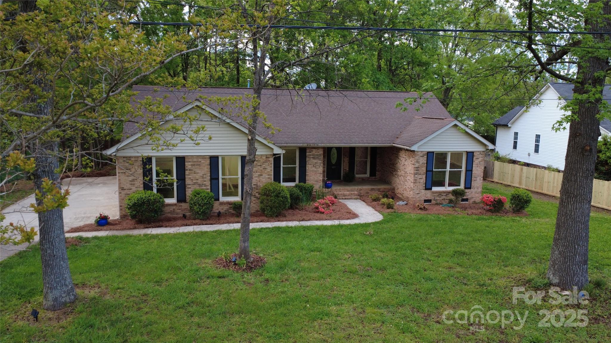 a front view of a house with a yard patio and green space