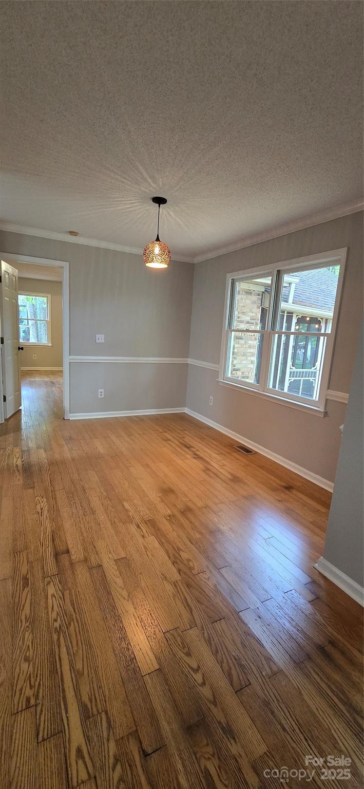 413 Parallel Drive Harrisburg, NC 28075 - Photo 13 of 40 an empty room with wooden floor and windows