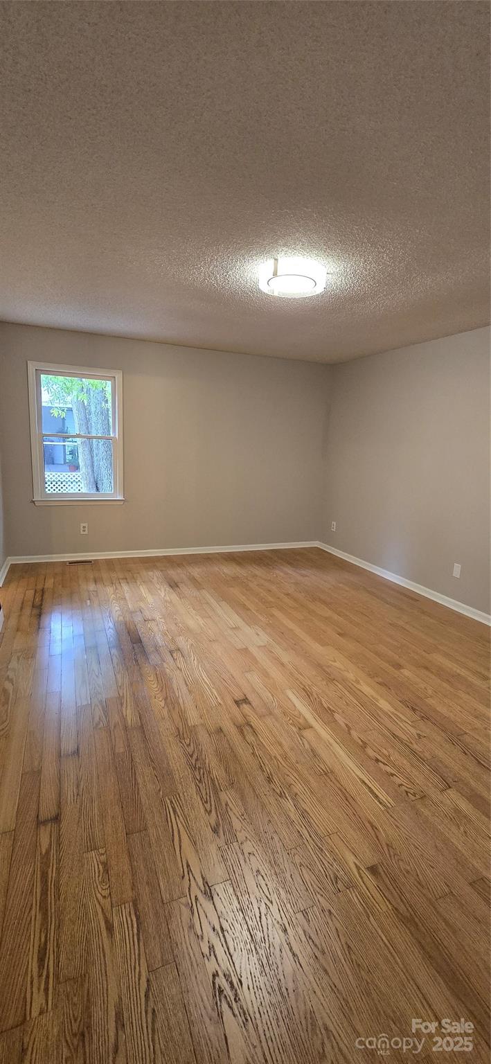 413 Parallel Drive Harrisburg, NC 28075 - Photo 15 of 40 an empty room with wooden floor and windows