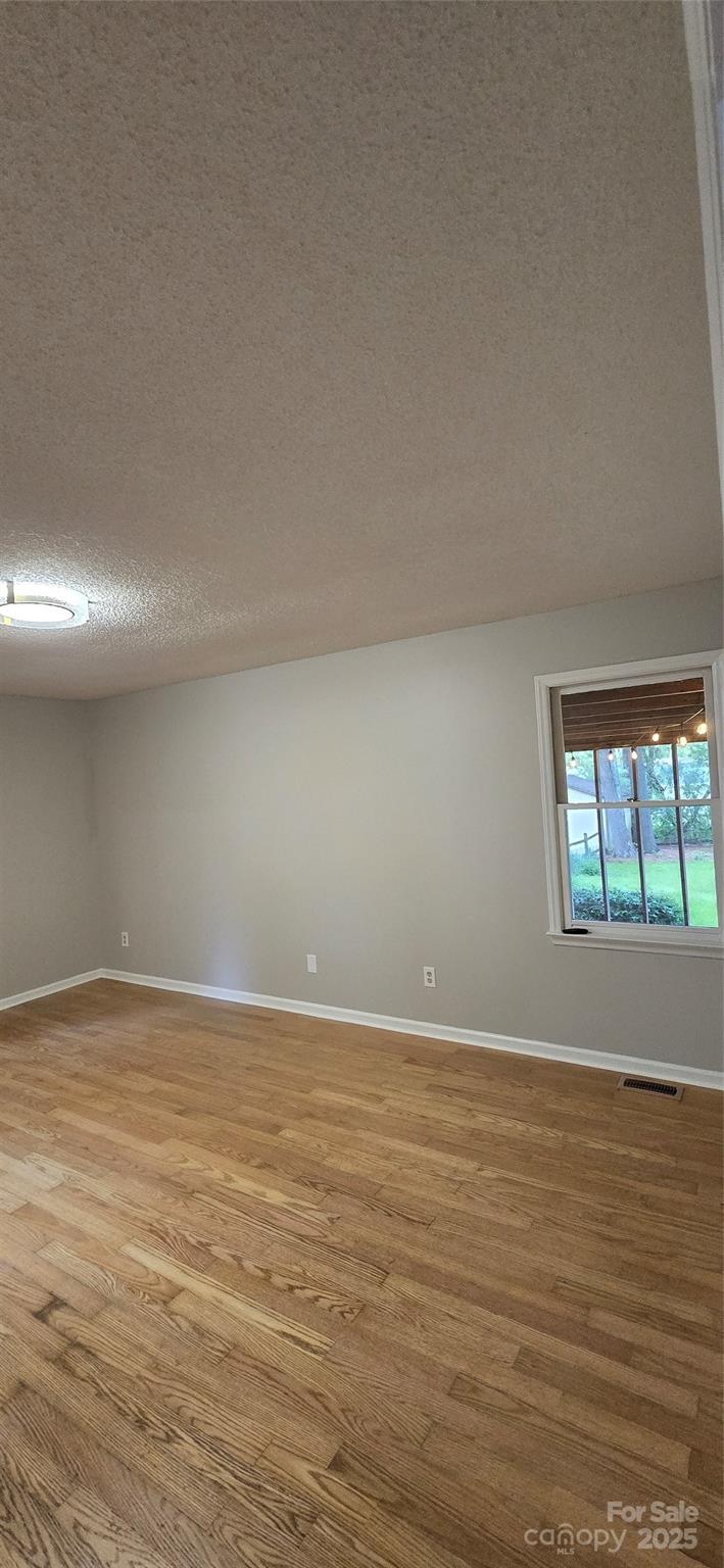 413 Parallel Drive Harrisburg, NC 28075 - Photo 16 of 40 a view of an empty room with wooden floor and a window