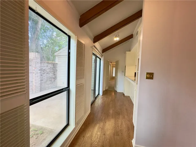 a view of a hallway with wooden floor and a floor to ceiling window