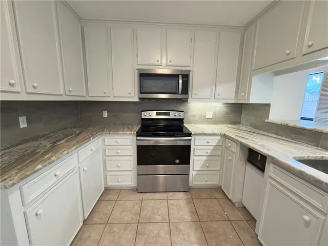 a kitchen with cabinets stainless steel appliances and a counter space