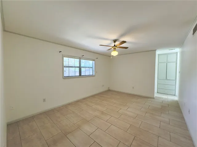an empty room with fan and windows