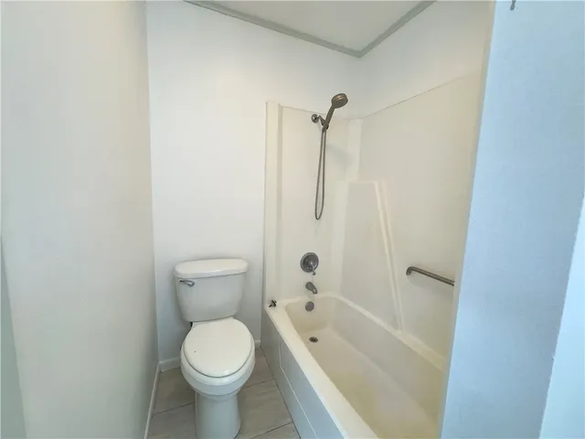 a white toilet sitting next to a bath tub